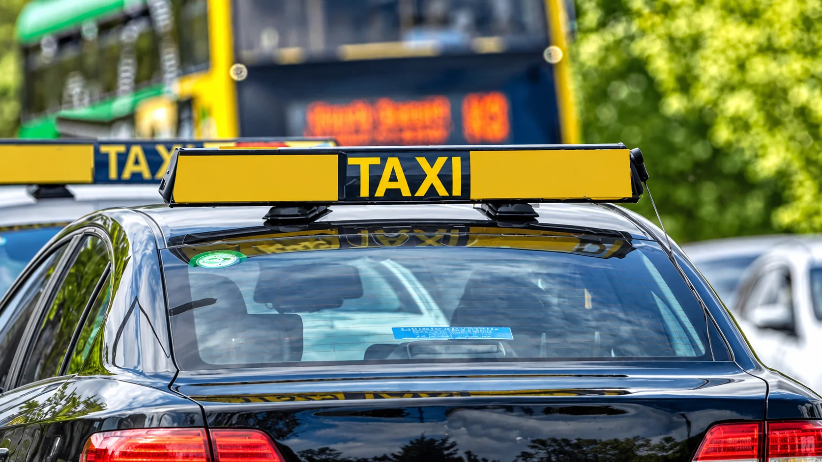 Taxi roof signs mounted on vehicles in an Irish street scene